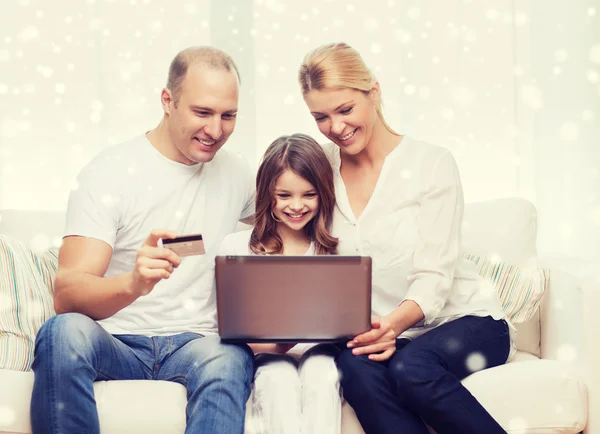 Família feliz com computador portátil e cartão de crédito — Fotografia de Stock