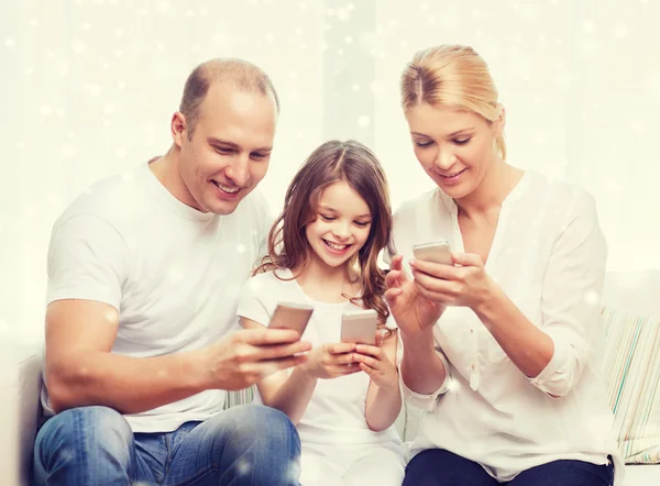 Famille heureuse avec smartphones à la maison — Photo