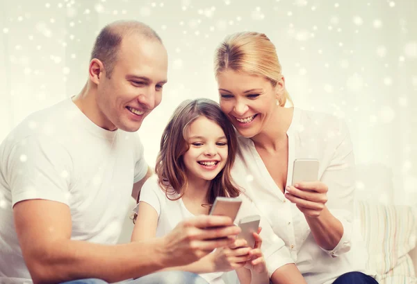 Ευτυχισμένη οικογένεια με smartphones στο σπίτι — Φωτογραφία Αρχείου