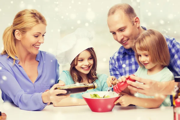 Glückliche Familie mit zwei Kindern, die zu Hause Salat zubereiten — Stockfoto