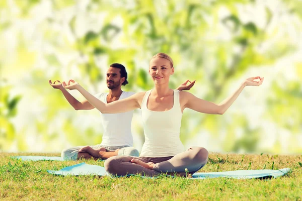 Glimlachend paar oefeningen maken yoga buiten — Stockfoto