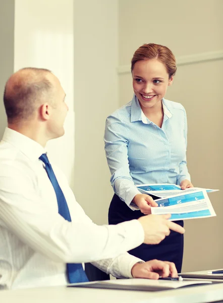 Uśmiechnięta kobieta papierów dając człowiekowi w biurze — Zdjęcie stockowe