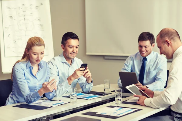Smiling business people with gadgets in office — Stock Photo, Image
