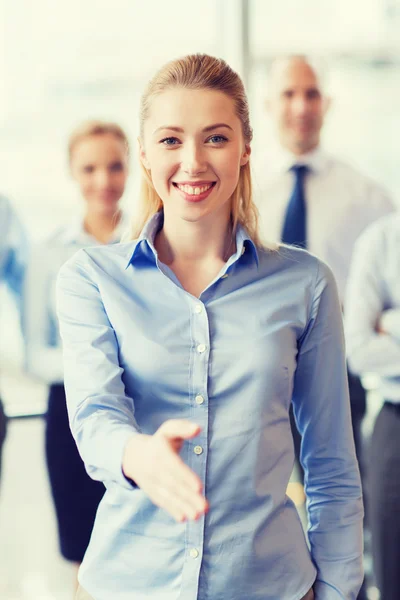 Glimlachende zakenvrouw handdruk maken in office — Stockfoto