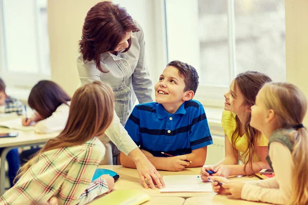 Group of school kids writing test in classroom — Stock Photo, Image