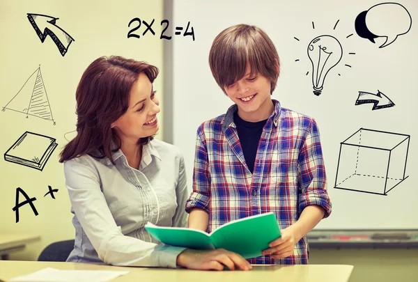 School boy with notebook and teacher in classroom — Stock Photo, Image