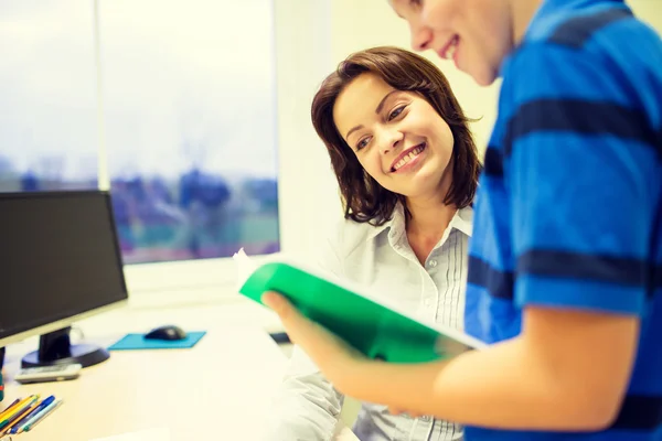 Colegial con cuaderno y profesor en aula — Foto de Stock