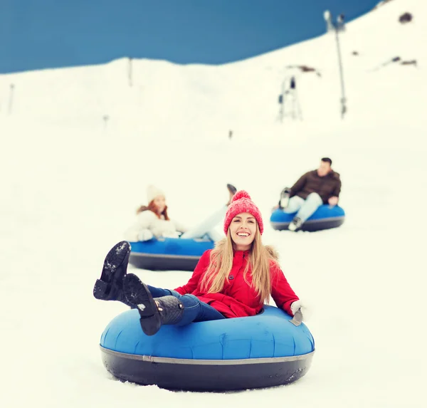 Group of happy friends sliding down on snow tubes — Stock Photo, Image