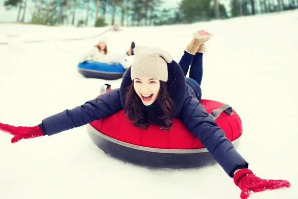 Groupe d'amis heureux glissant vers le bas sur des tubes à neige — Photo