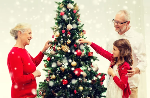 笑みを浮かべて家族飾るクリスマス ツリー自宅 — ストック写真