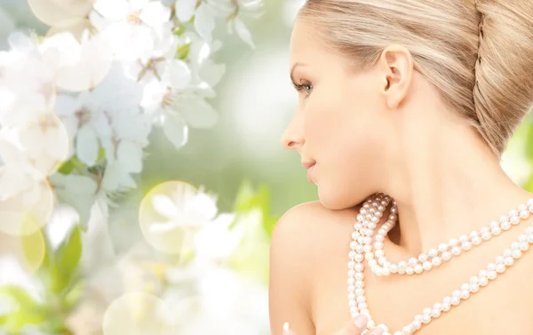 Mujer con collar de perlas sobre flor de cerezo —  Fotos de Stock