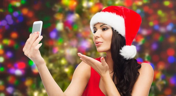 Woman in santa hat taking selfie by smartphone — Stock Photo, Image