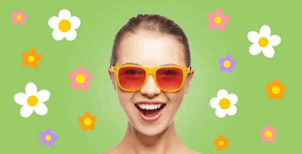 Happy teenage hippy girl in shades with flowers — Stockfoto