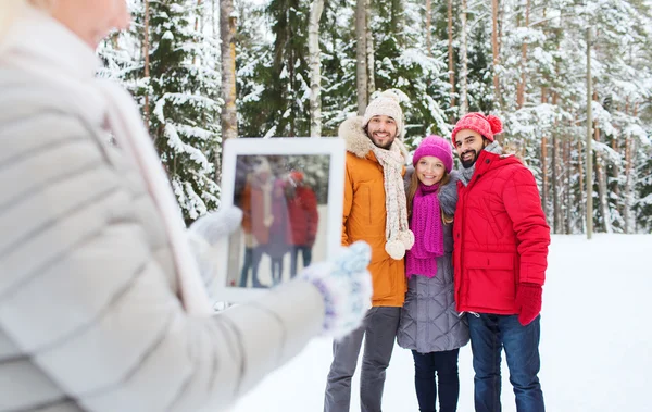 Smilende venner med tablettkjerne i vinterskogen – stockfoto