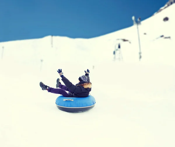 Happy young man sliding down on snow tube Stock Image