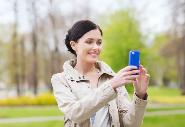 Smiling woman taking picture with smartphone — Stock Photo, Image