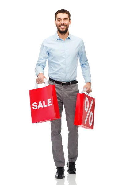 Uomo sorridente con shopping bag rossa — Foto Stock