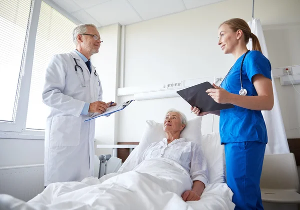 Arzt und Krankenschwester besuchen Seniorin im Krankenhaus — Stockfoto