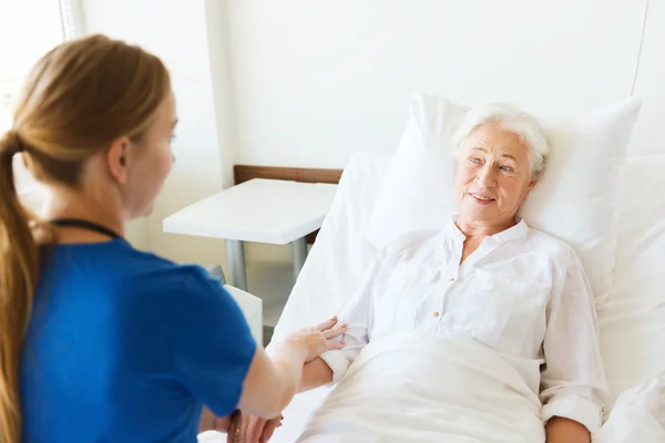 Médico o enfermero que visita a una mujer mayor en el hospital — Foto de Stock
