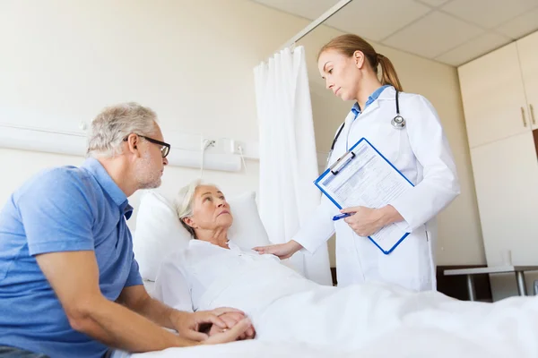 Femme âgée et médecin avec presse-papiers à l'hôpital — Photo