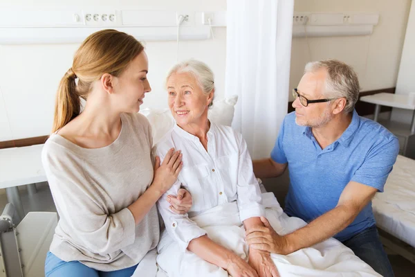 Szczęśliwa rodzina odwiedza starszą kobietę w szpitalu — Zdjęcie stockowe