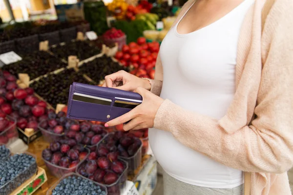 Mujer embarazada con billetera comprando alimentos en el mercado — Foto de Stock