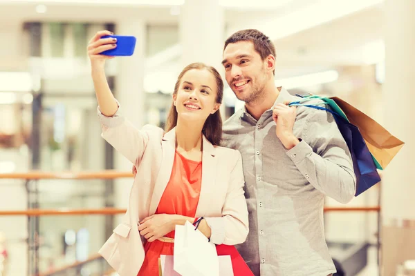 Coppia felice con smartphone scattare selfie nel centro commerciale — Foto Stock