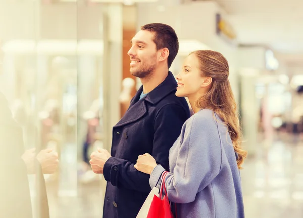 쇼핑몰에 쇼핑백을 가지고 있는 행복 한 젊은 부부 — 스톡 사진