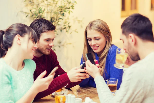 Group of friends with smartphones meeting at cafe — Stock Photo, Image