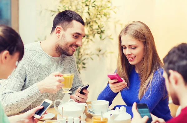 Grupo de amigos con teléfonos inteligentes reunión en la cafetería —  Fotos de Stock