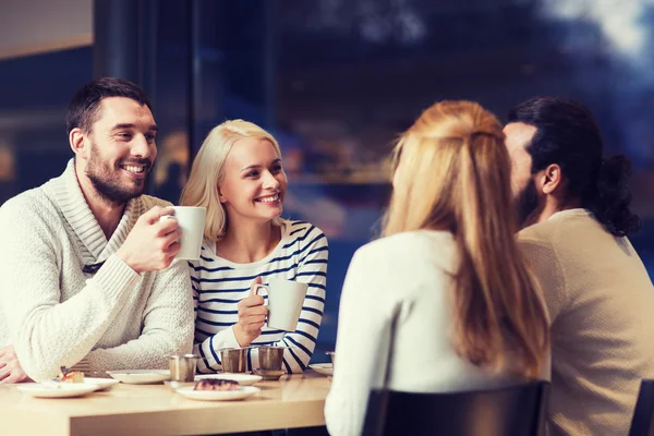 Счастливые друзья, встречающиеся и пьющие чай или кофе — стоковое фото
