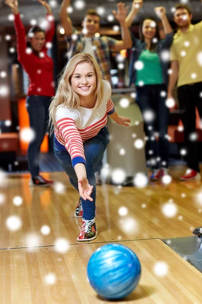 Šťastná mladá žena házení míče v bowling Clubu — Stock fotografie