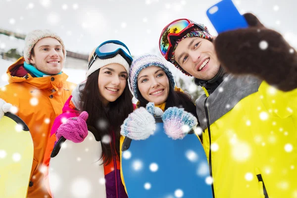 Happy přátelé se snowboardy a smartphone — Stock fotografie