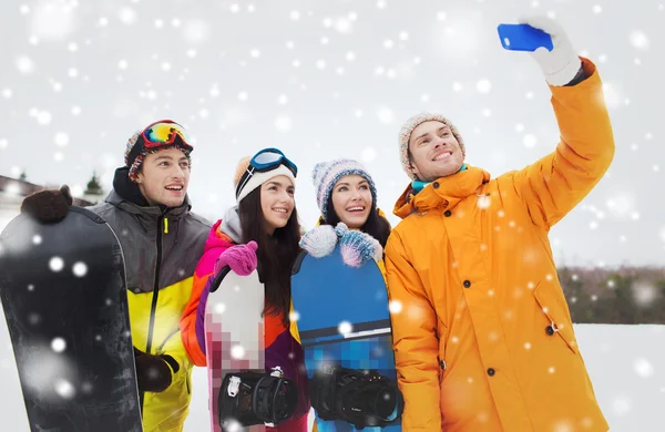 Amigos felices con tablas de snowboard y smartphone — Foto de Stock