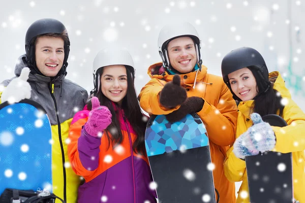 Glückliche Freunde in Helmen mit Snowboards — Stockfoto