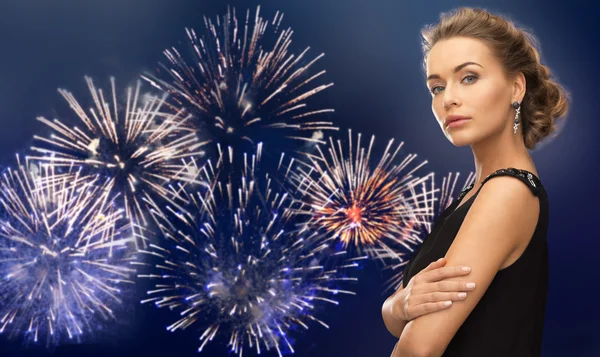 Bela mulher vestindo brincos sobre fogos de artifício — Fotografia de Stock