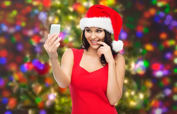 Woman in santa hat taking selfie by smartphone — Stock Photo, Image