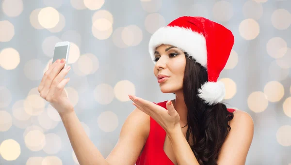 Woman in santa hat taking selfie by smartphone — Stock Photo, Image