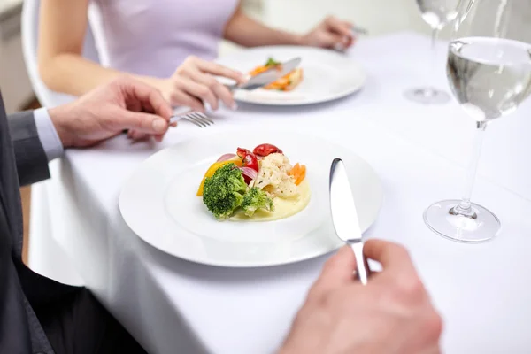 Close up of couple eating appetizers at restaurant — Stock Photo, Image