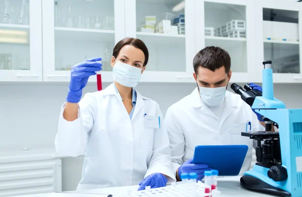 Jovens cientistas que fazem testes ou pesquisas em laboratório — Fotografia de Stock