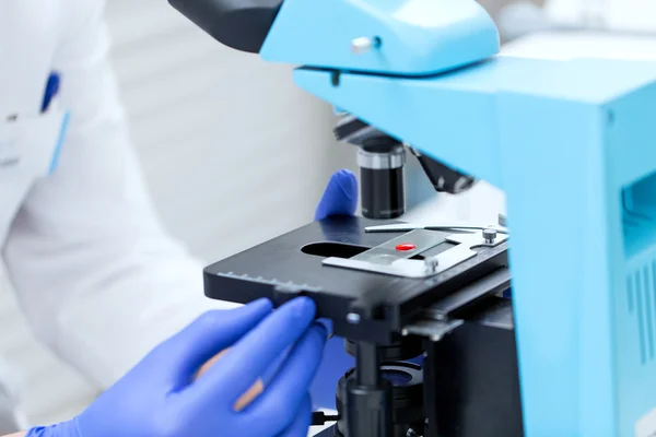 Close up of hands with microscope and blood sample — 스톡 사진