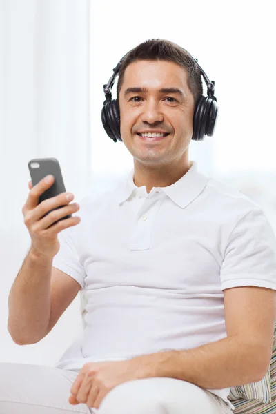 Hombre feliz con teléfono inteligente y auriculares —  Fotos de Stock