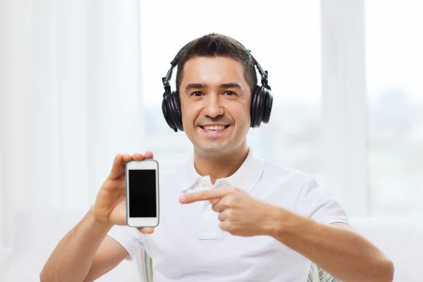 Homem feliz com smartphone e fones de ouvido — Fotografia de Stock