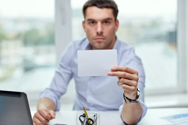 Empresário mostrando cartão de papel em branco no escritório — Fotografia de Stock