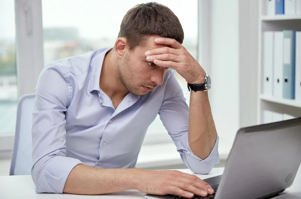 Homem de negócios estressado com laptop no escritório — Fotografia de Stock