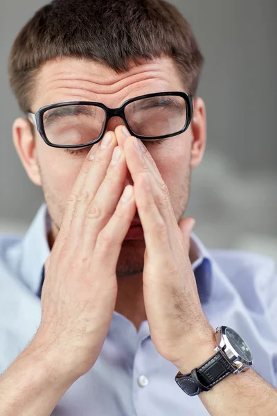 Hombre de negocios cansado con anteojos en la oficina —  Fotos de Stock