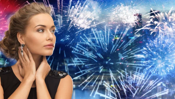 Beautiful woman wearing earrings over firework Stockbild