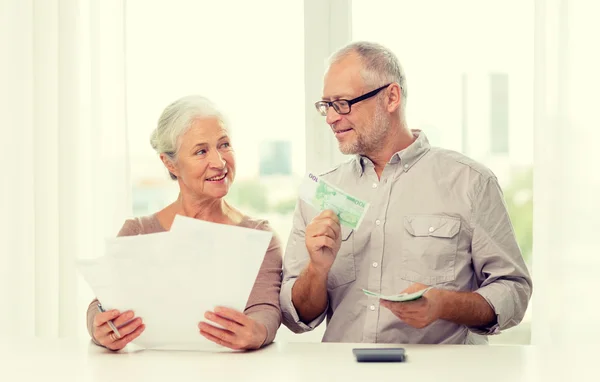 Senior couple with money and calculator at home — Stock Photo, Image