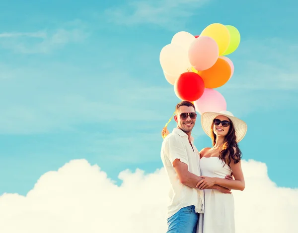 Smiling couple with air balloons outdoors — Stock Photo, Image