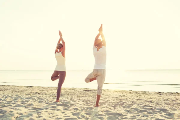 Paar maken van yoga oefeningen buiten vanaf de achterkant — Stockfoto